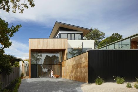 Modern house with a person walking their dog in front
