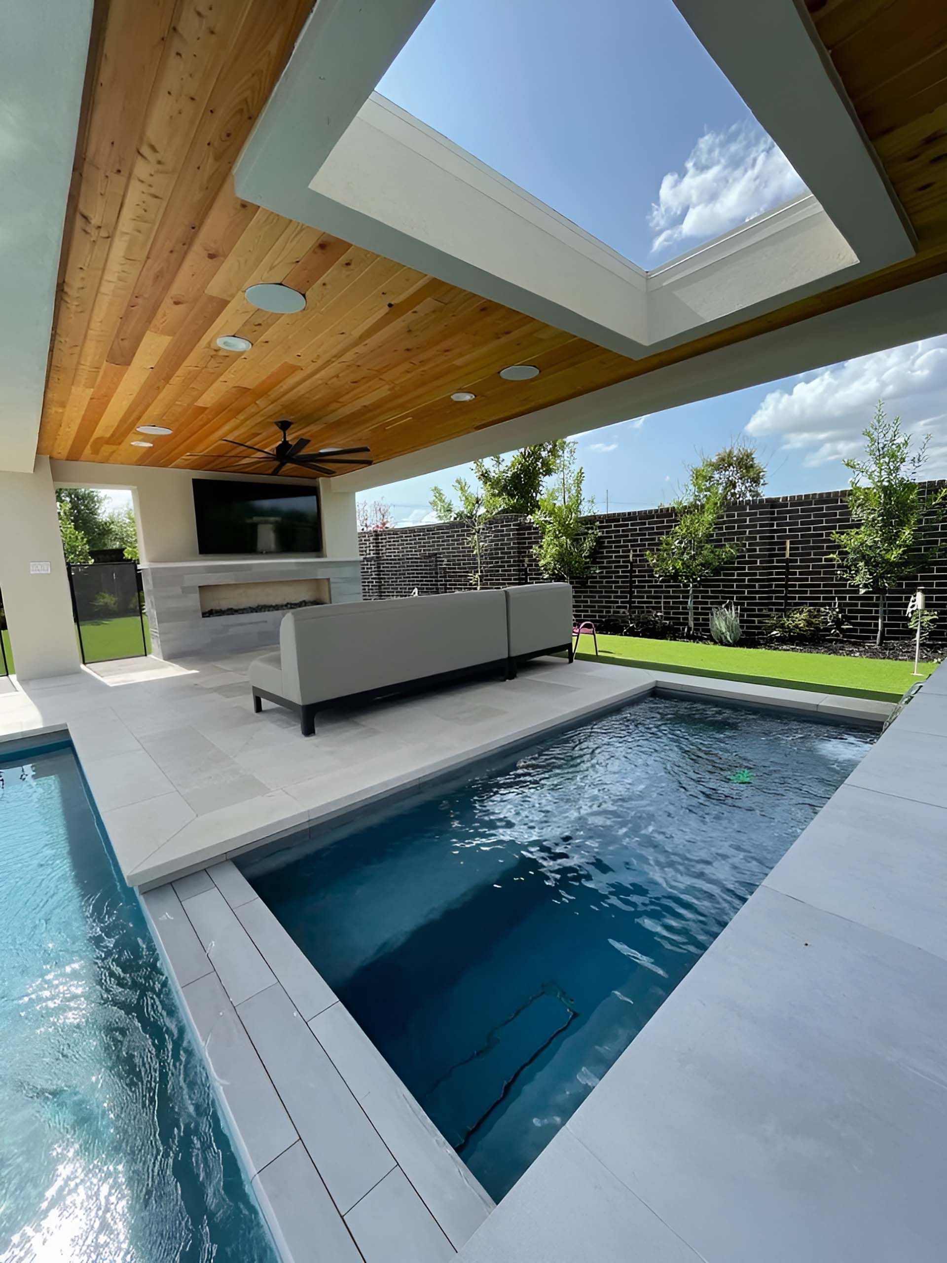 Patio with a pool and an outside tv and couch